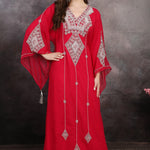 A woman wearing a red long sleeve caftan with silver color bead embellishments. The caftan has a straight cut and appears to be made of polyester georgette fabric.