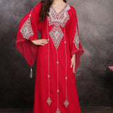 A woman wearing a red long sleeve caftan with silver color bead embellishments. The caftan has a straight cut and appears to be made of polyester georgette fabric.