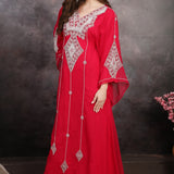 Woman in a red embroidered dress against a dark background