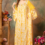 A woman modeling a yellow and white geometric patterned cotton kaftan with 3/4 length sleeves and a V-neck.