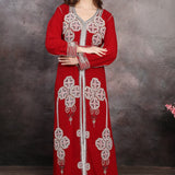 A woman wearing a red Moroccan caftan with silver and multicolor bead embellishments.