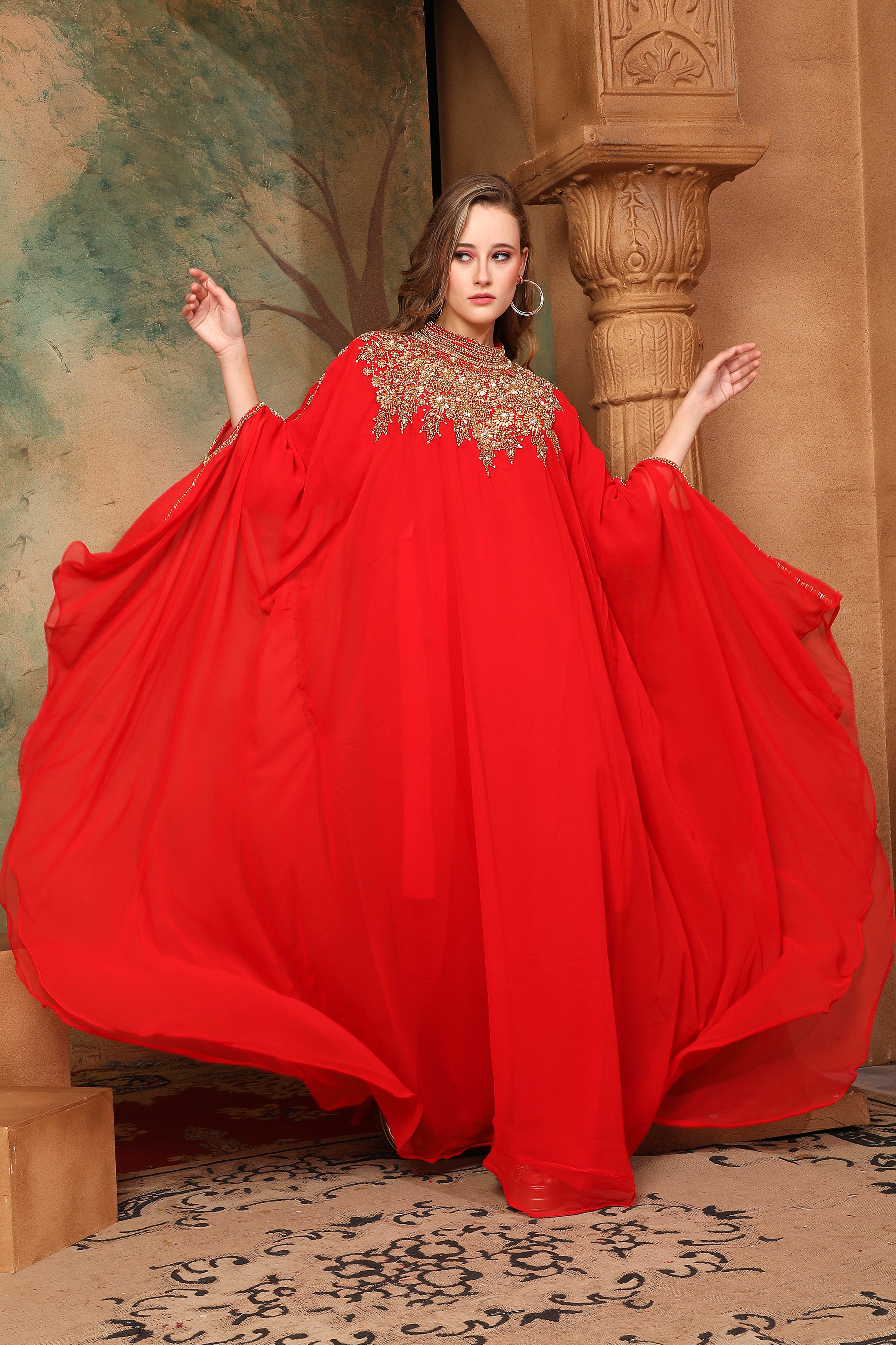 A woman wearing a red, traditional, embellished kaftan with a belt, posing in a grand setting with decorative walls and ceiling.