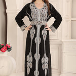 A woman wearing a black and silver Moroccan caftan with floral bead embroidery.