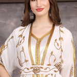 Close-up of hand-embellished gold beads on Moroccan georgette caftan fabric.