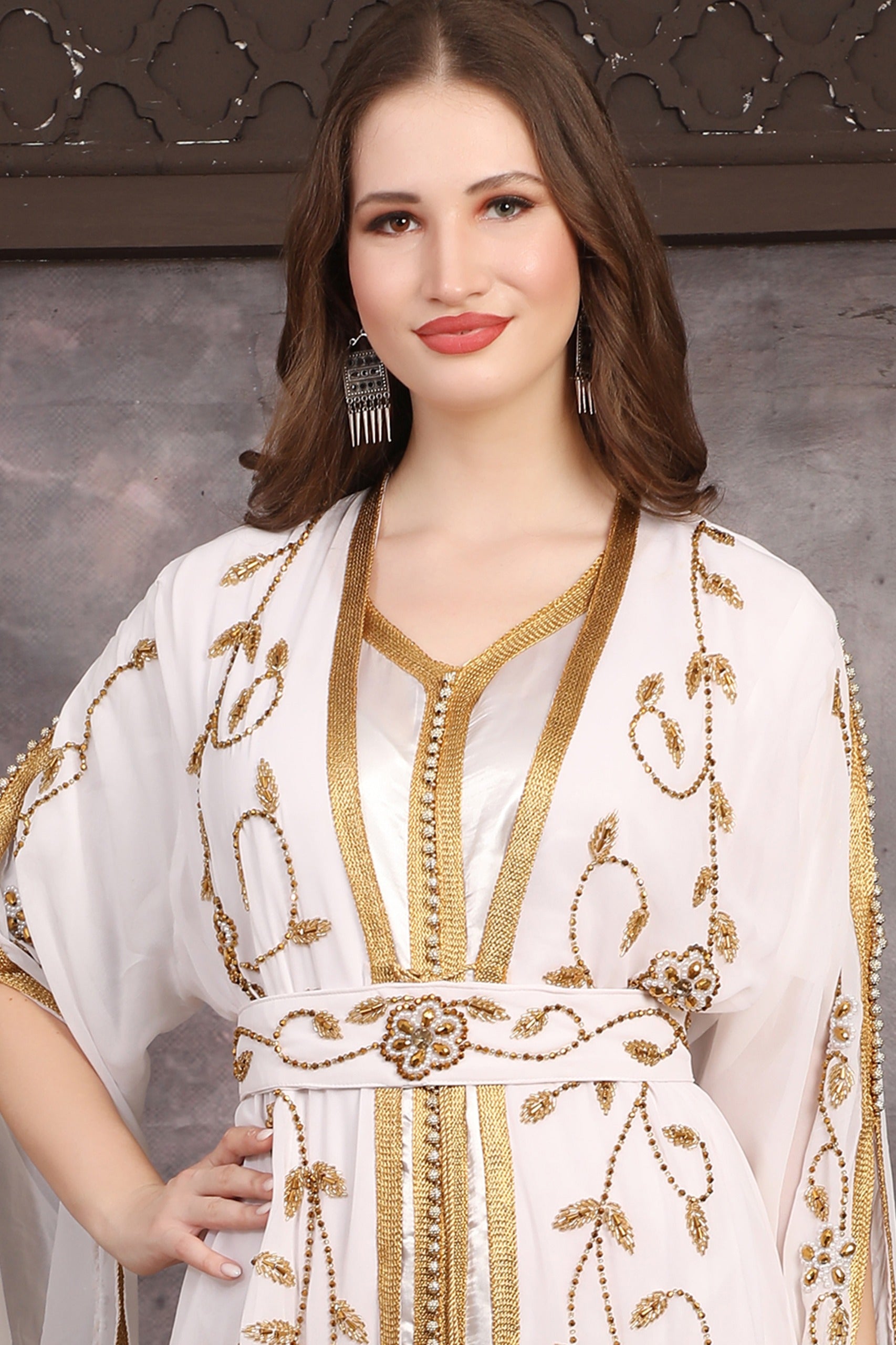 Close-up of hand-embellished gold beads on Moroccan georgette caftan fabric.